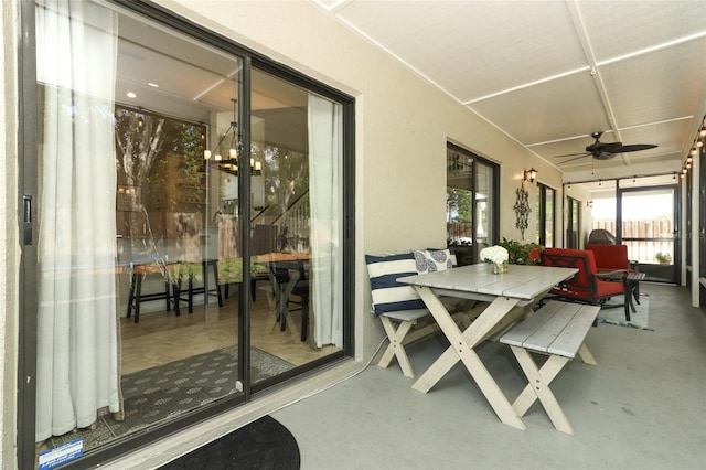 sunroom with outdoor dining area and a ceiling fan