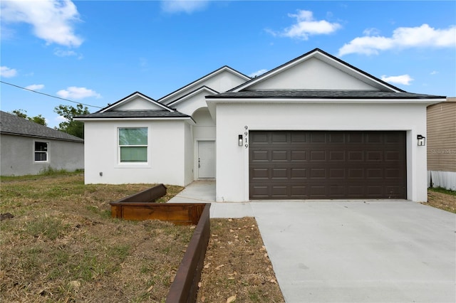 ranch-style house featuring a garage, a shingled roof, stucco siding, and driveway