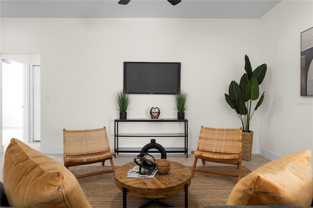 sitting room featuring baseboards, a ceiling fan, and tile patterned flooring