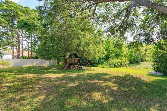 view of yard with fence and a playground