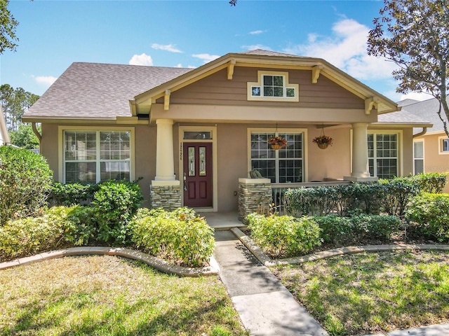 12724 Bideford Ave, Windermere, FL 34786 - view of front facade featuring stucco siding, a porch, and a shingled roof