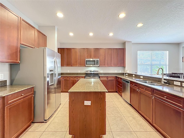 12724 Bideford Ave, Windermere, FL 34786 - kitchen featuring stainless steel appliances, a kitchen island, light stone counters, recessed lighting, and light tile patterned floors