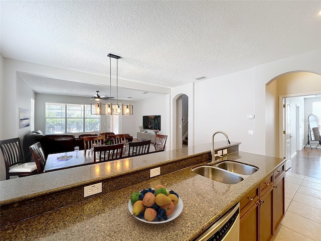 12724 Bideford Ave, Windermere, FL 34786 - kitchen featuring arched walkways, open floor plan, dishwasher, brown cabinets, and dark stone countertops