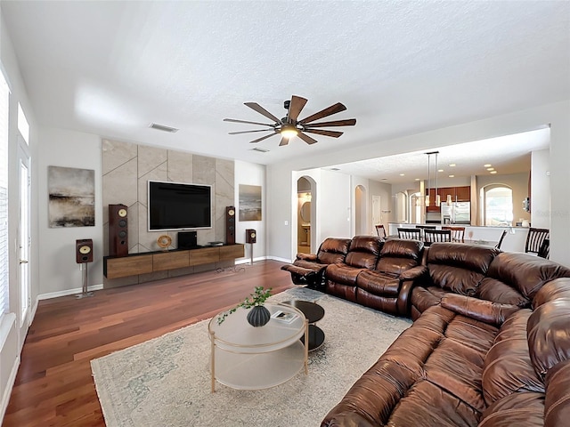 12724 Bideford Ave, Windermere, FL 34786 - living area with wood finished floors, ceiling fan, arched walkways, and a textured ceiling