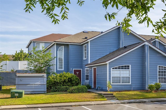 traditional-style house with fence, uncovered parking, and a front yard