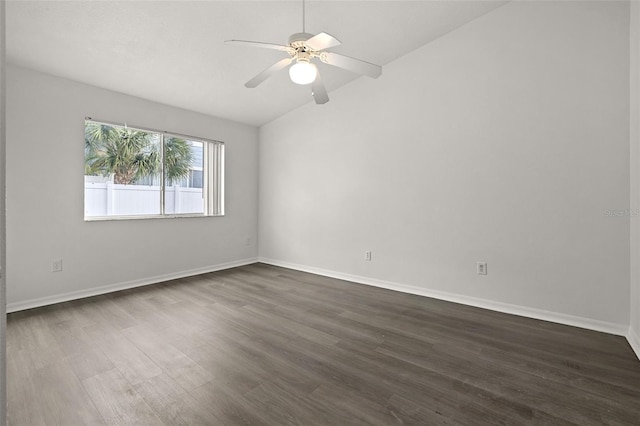 spare room with baseboards, ceiling fan, vaulted ceiling, and dark wood finished floors