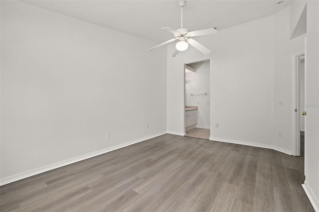 unfurnished bedroom featuring baseboards, ceiling fan, wood finished floors, and connected bathroom