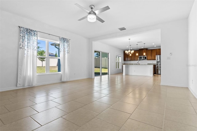 683 Campo Ln, Davenport, FL 33837 - unfurnished living room with light tile patterned flooring, baseboards, visible vents, and ceiling fan with notable chandelier