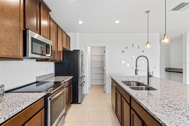 683 Campo Ln, Davenport, FL 33837 - kitchen featuring light stone counters, a sink, stainless steel appliances, visible vents, and pendant lighting