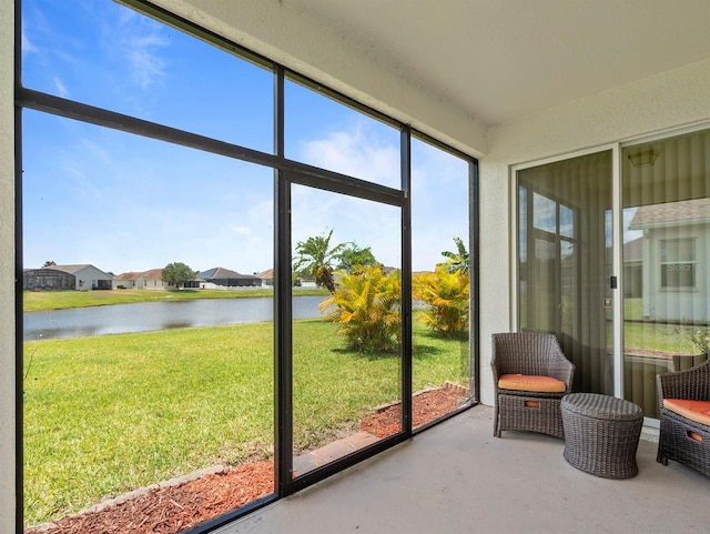 sunroom / solarium featuring a residential view and a water view