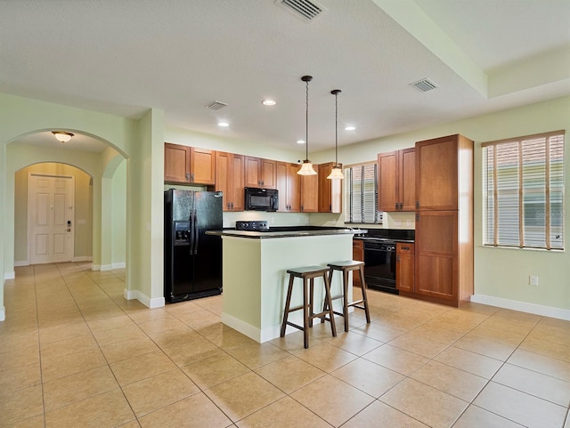 kitchen with arched walkways, dark countertops, visible vents, and black appliances