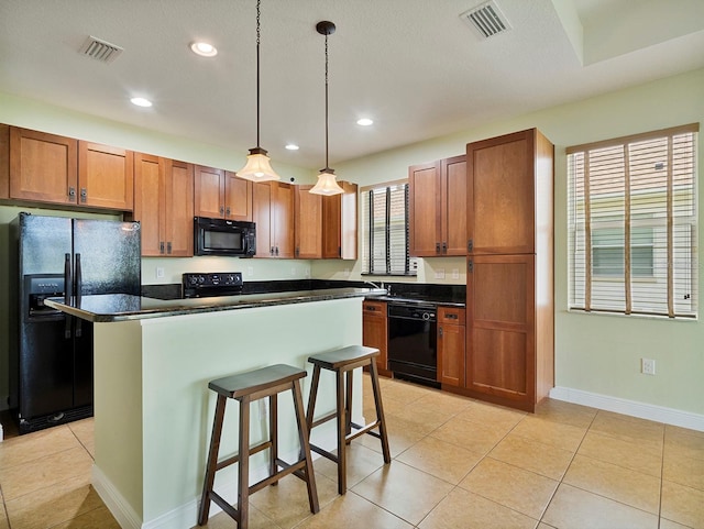 kitchen with visible vents, black appliances, and dark countertops