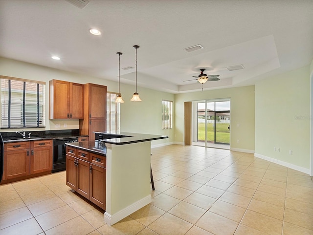 kitchen with open floor plan, a raised ceiling, light tile patterned floors, and black dishwasher