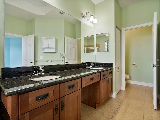 bathroom featuring double vanity, a sink, tile patterned floors, and toilet