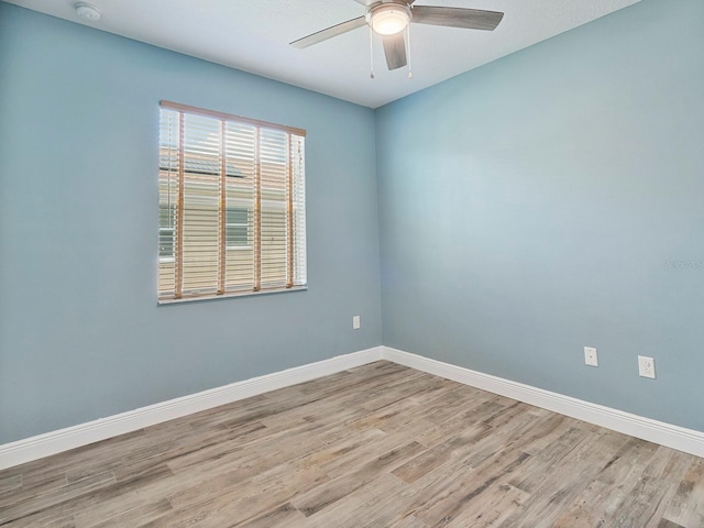 empty room featuring a ceiling fan, baseboards, and wood finished floors