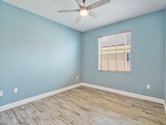empty room with baseboards, ceiling fan, and wood finished floors
