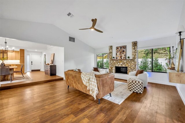 1218 Fairway Dr, Winter Park, FL 32792 - living room featuring hardwood / wood-style flooring, vaulted ceiling, a stone fireplace, ceiling fan, and a chandelier