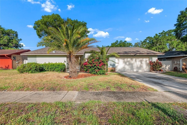 single story home with an attached garage, driveway, and a front yard