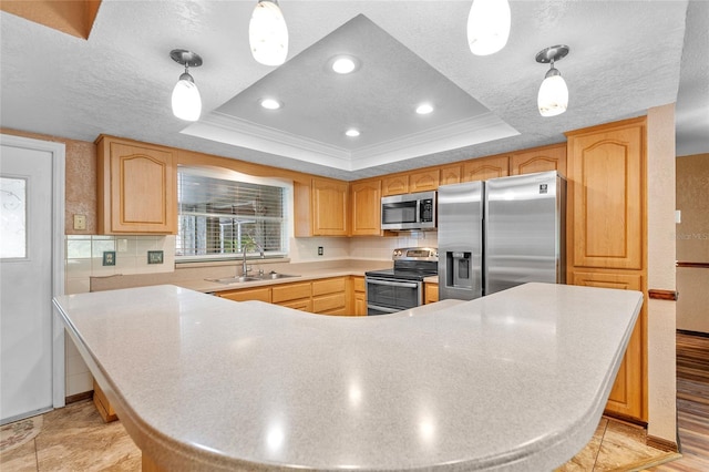 kitchen featuring crown molding, appliances with stainless steel finishes, a raised ceiling, and a sink