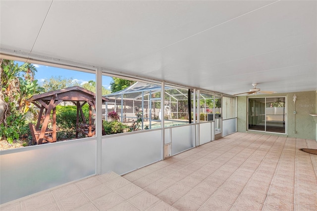 unfurnished sunroom featuring ceiling fan