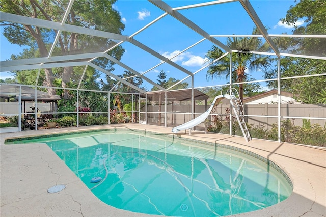 view of pool featuring a patio area, a fenced in pool, a water slide, and fence