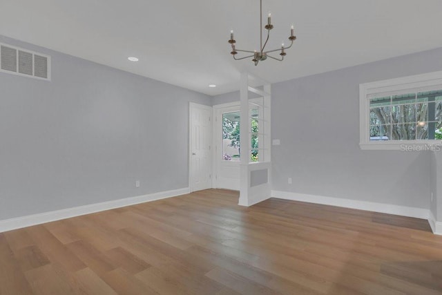 3605 Pershing Ave, Orlando, FL 32812 - empty room featuring plenty of natural light, a chandelier, wood finished floors, baseboards, and recessed lighting