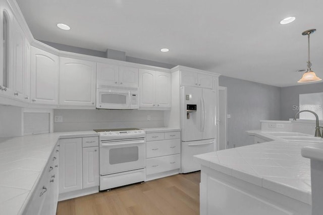 3605 Pershing Ave, Orlando, FL 32812 - kitchen featuring white appliances, a sink, tile counters, white cabinets, and recessed lighting