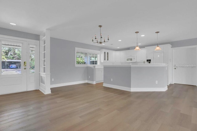 3605 Pershing Ave, Orlando, FL 32812 - unfurnished living room with a chandelier, recessed lighting, light wood-style floors, and baseboards