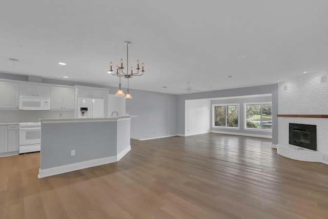 3605 Pershing Ave, Orlando, FL 32812 - unfurnished living room featuring recessed lighting, a fireplace, light wood-style flooring, a chandelier, and ceiling fan