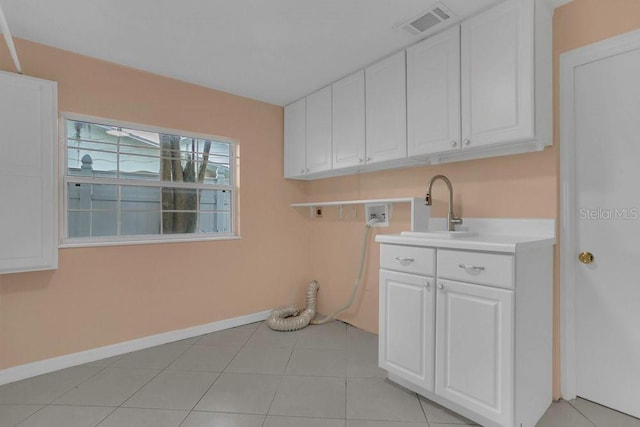 3605 Pershing Ave, Orlando, FL 32812 - laundry area featuring baseboards, cabinet space, hookup for a washing machine, and light tile patterned flooring