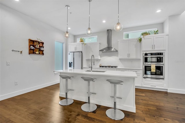 kitchen with a sink, wall chimney exhaust hood, double oven, fridge with ice dispenser, and light countertops