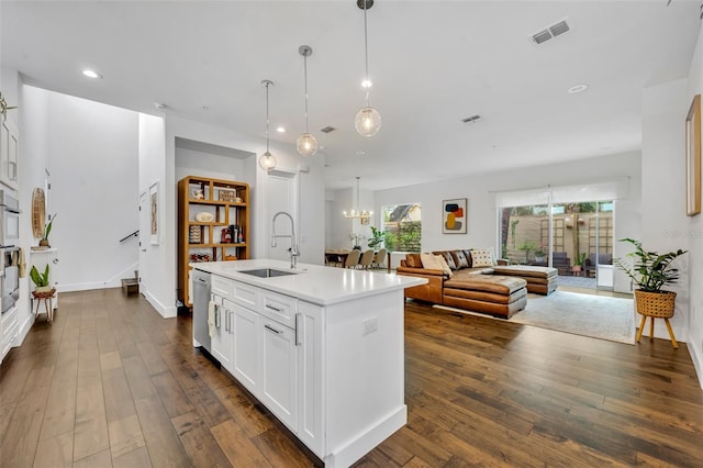 kitchen with a sink, open floor plan, visible vents, dark wood-style flooring, and light countertops