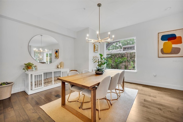 dining room featuring baseboards, arched walkways, wood-type flooring, and a notable chandelier