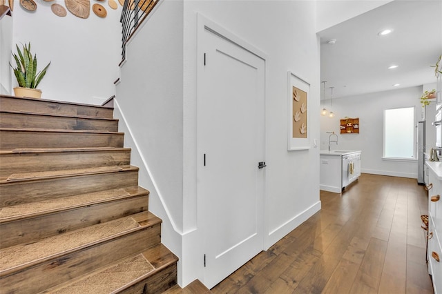 stairs with wood-type flooring, baseboards, and recessed lighting