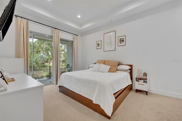 bedroom featuring light colored carpet, a tray ceiling, access to exterior, and recessed lighting