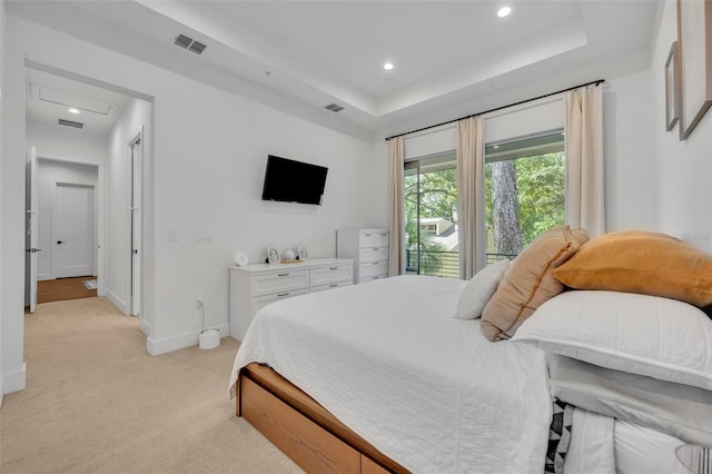 bedroom with a tray ceiling, visible vents, baseboards, light colored carpet, and recessed lighting