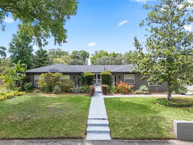 4118 Teriwood Ave, Orlando, FL 32812 - ranch-style home with stucco siding, roof with shingles, and a front lawn