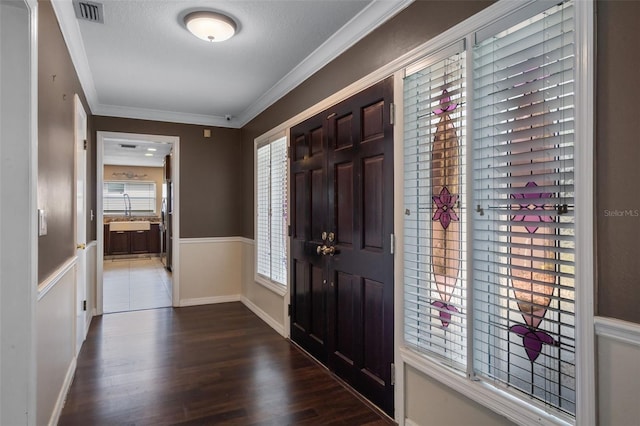 4118 Teriwood Ave, Orlando, FL 32812 - foyer entrance featuring crown molding, visible vents, wood finished floors, and a wainscoted wall