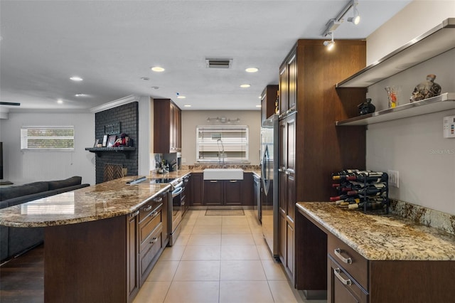 4118 Teriwood Ave, Orlando, FL 32812 - kitchen featuring light stone counters, a sink, appliances with stainless steel finishes, and a peninsula