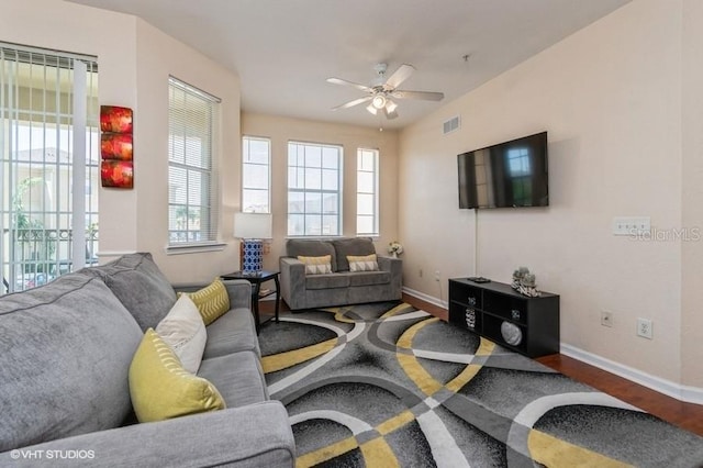 living room featuring baseboards, ceiling fan, wood finished floors, and visible vents