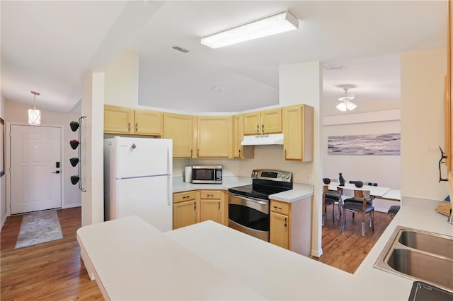 kitchen with light brown cabinets, stainless steel appliances, lofted ceiling, and under cabinet range hood