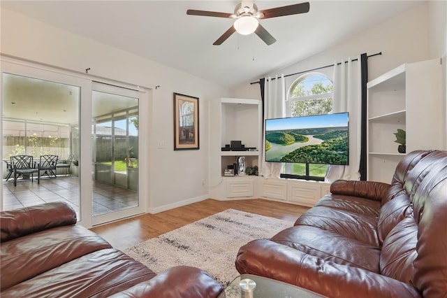 living area featuring baseboards, a ceiling fan, wood finished floors, and vaulted ceiling