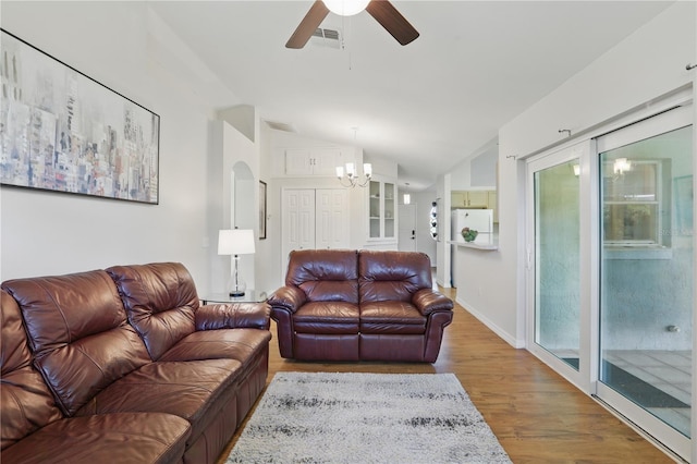 living area featuring visible vents, ceiling fan with notable chandelier, wood finished floors, and lofted ceiling