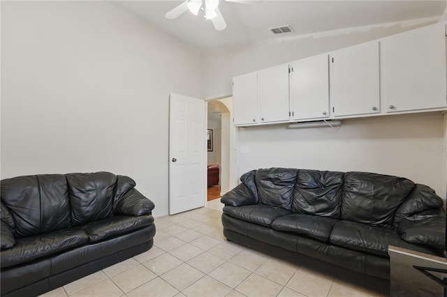 living area featuring light tile patterned flooring, arched walkways, a ceiling fan, lofted ceiling, and visible vents