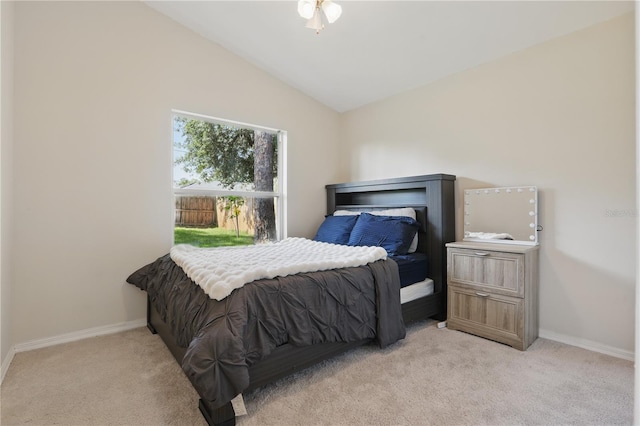 carpeted bedroom with baseboards and lofted ceiling