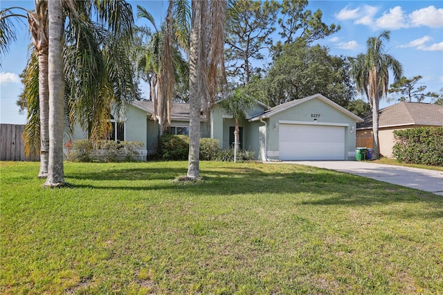 view of front facade with fence, an attached garage, a front lawn, stucco siding, and concrete driveway
