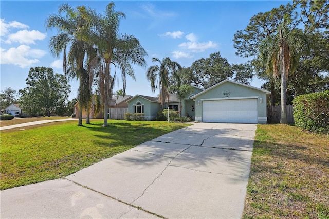 ranch-style house with fence, an attached garage, a front lawn, stucco siding, and concrete driveway