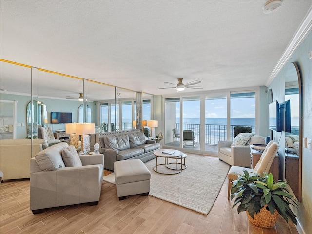 living room featuring ornamental molding, light wood finished floors, and ceiling fan