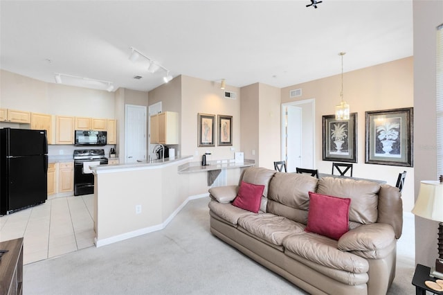 living room featuring track lighting, light colored carpet, baseboards, and light tile patterned flooring