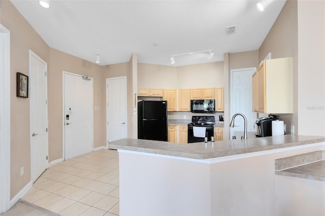 kitchen featuring black appliances, light brown cabinetry, a peninsula, light tile patterned floors, and light countertops